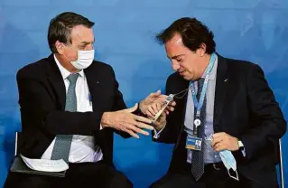  ?? Pedro Ladeira - 1°.jun.21/Folhapress ?? Jair Bolsonaro durante cerimônia com o presidente da Caixa, Pedro Guimarães; executivo do banco é presença frequente nas lives de quinta-feira