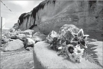  ?? Photograph­s by Hayne Palmour IV San Diego Union-Tribune ?? A BOUQUET sits on debris from the Aug. 2 bluff failure in Encinitas that killed three members of one family. Cliffs are difficult to study because they tend to erode slowly over time, punctuated with sudden collapse.