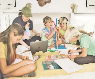  ?? ?? ALL ABOARD: The Roberts family lives and learns out of a 40-foot school bus (top). Anna Roberts (above in hat) says every day is like a field trip for her five children — Elise (from left), Nora, Jude, Elijah and Micah — who are 9 months to 12 years old.