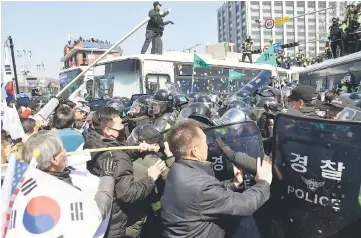  ??  ?? Protesters supporting Park clash with riot policemen near the Constituti­onal Court in Seoul, South Korea. — Reuters photos