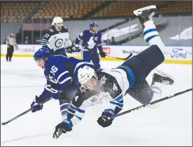  ?? CP PHOTO NATHAN DENETTE ?? Toronto Maple Leafs right wing Mitchell Marner (16) scores on an empty net and take a hit from Winnipeg Jets defenceman Neal Pionk (4) during third period NHL hockey action in Toronto on Monday.