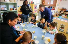  ?? RAY CHAVEZ — BAY AREA NEWS GROUP ?? Contra Costa County Supervisor John Gioia, right, talks to snacking children during a visit to the Head Start childcare program at the George Miller III Center in Richmond on Friday.