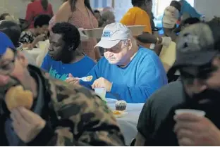  ?? PHOTOS BY CARLINE JEAN/SUN SENTINEL ?? Edward Mazur, 69, who lives in the Fort Lauderdale area, eats a Christmas Eve meal served by volunteers from several Broward County churches.