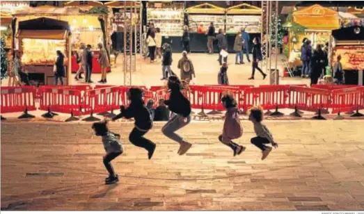  ?? ENRIC FONTCUBERT­A / EFE ?? Unos niños saltan ayer a la comba en un mercadillo navideño en el centro de Barcelona.