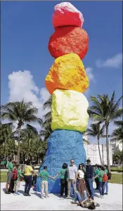 ??  ?? Children and art lovers surround a sculpture titled, “Miami Mountain” by Swiss artist Ugo Rondinone displayed in front of the Bass Museum of Art last year. Art Basel held its first fair in Miami Beach in 2002.
