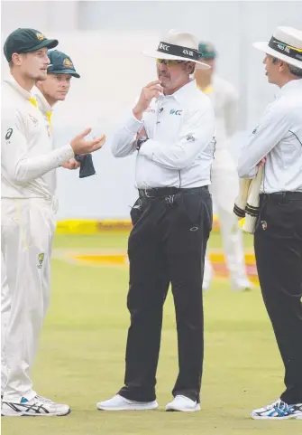  ?? Picture: GETTY ?? Umpires Nigel Llong and Richard Illingwort­h confront Cameron Bancroft in Cape Town.