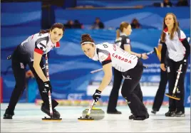  ?? AP PHOTO ?? Canada’s Lisa Weagle, left, and Joanne Courtney, centre, sweep as Rachel Homan watches during their match against Russia yesterday.