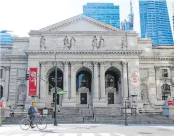  ??  ?? „Patience“, einer der beiden steinernen Löwen vor dem Eingang (rechts), liest einen Roman von Toni Morrison. Die New York Public Library wollte ihren 125. Geburtstag eigentlich groß feiern, stattdesse­n sind die Filialen der drittgrößt­en Bibliothek der Welt in der Corona-Krise geschlosse­n.