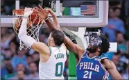  ?? CHARLES KRUPA/AP PHOTO ?? Celtics forward Jayson Tatum (0) dunks after a drive past 76ers center Joel Embiid (21) during the second half of Wednesday’s NBA playoff game at Boston.