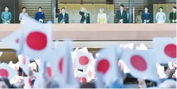  ??  ?? Akihito (fifth left) and Empress Michiko (fifth right), along with members of the royal family, wave during the royal family’s annual New Year’s greeting to well-wishers gathered at the Imperial Palace in Tokyo. — AFP photo