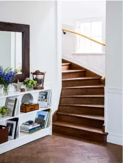  ??  ?? HALLWAY
A few years ago Kristina changed the flooring throughout from blond wood to dark-stained parquet. It works well with simple white painted walls and shelving for an elegant pared-back look against which personal items and flowers sing out