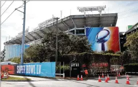  ?? ASSOCIATED PRESS ?? A sign featuring the Lombardi Trophy can be seen outside Raymond James Stadium in Tampa. The stadium will host Super Bowl 55 on Feb. 7.