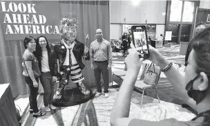  ?? JOHN RAOUX/ASSOCIATED PRESS ?? Attendees at the Conservati­ve Political Action Conference pose for a photo next to a statue of former President Donald Trump on Saturday in Orlando, Fla. Trump spoke at CPAC on Sunday, making it clear he intends to remain in the political arena.