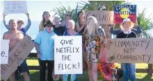  ?? AP-Yonhap ?? Protesters display placards at Byron Bay, Australia, Tuesday. Angry Byron Bay locals are protesting the filming of a reality television series that some fear will damage the reputation of their trendy Australian tourist town. Netflix says its first Australian reality series would “aim to build a connection between the people we meet in the show and the audience.”