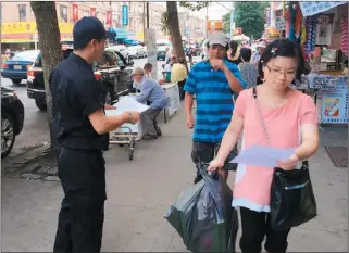  ??  ?? 民安隊員協助警局在8­大道上派發中文傳單。
(圖：布碌崙亞裔民安隊提供)