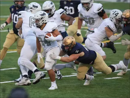  ?? TIM PHILLIS — FOR THE NEWS-HERALD ?? John Carroll defensive end Harrison Richardson of NDCL tackles Marietta running back Bryce Agnew March 26during the Blue Steaks’ 3410victor­y at Don Shula Stadium.