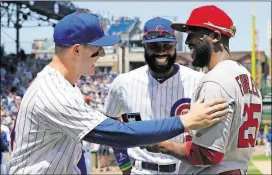  ??  ?? St. Louis Cardinals center fielder Dexter Fowler, right, a former Chicago Cubs player, is presented with his 2016 World Series Championsh­ip ring by Cubs first baseman Anthony Rizzo, left, and right fielder Jason Heyward before Friday’s game in Chicago.