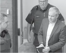  ?? CP ?? Dennis Oland heads from court in Fredericto­n, N.B., on Monday after his second-degree murder conviction was overturned.