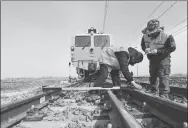  ?? GUAN MINGYUE / FOR CHINA DAILY ?? China Railway Harbin Group workers carry out maintenanc­e work on the Harbin-Jiamusi high-speed railway line in May.