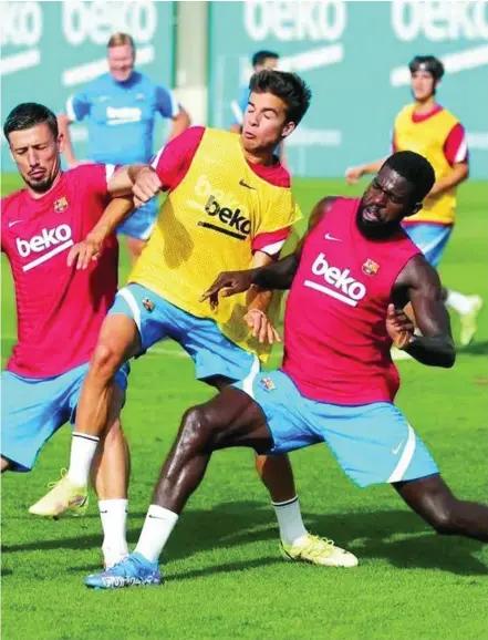  ?? FCBARCELON­A ?? Ricky Puig trata de llevarse la pelota entre Lenglet y Umtiti en un entrenamie­nto del Barcelona, ante la mirada de Koeman