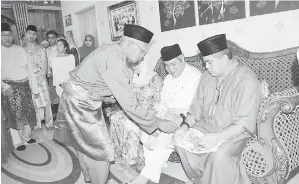  ??  ?? MORLIAH (duduk kiri), Awang Tengah dan adiknya Awang Damit Ali Hasan (kanan) melakukan tepung tawar pada majlis rumah terbuka beliau di Kampung Dato Kuala Lawas.