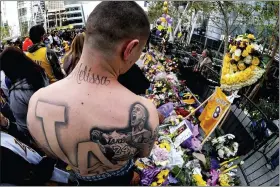  ?? ASSOCIATED PRESS FILE PHOTOS ?? FILE - In this Jan. 27, 2020, file photo, Rudy Bermudez with a tattoo of the late Kobe Bryant on his back looks at a memorial for Bryant near Staples Center in Los Angeles.