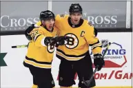  ?? Winslow Townson / Associated Press ?? The Boston Bruins’ Patrice Bergeron, right, celebrates with Brad Marchand, left, after Marchand scored against the Pittsburgh Penguins during the second period on Saturday in Boston.