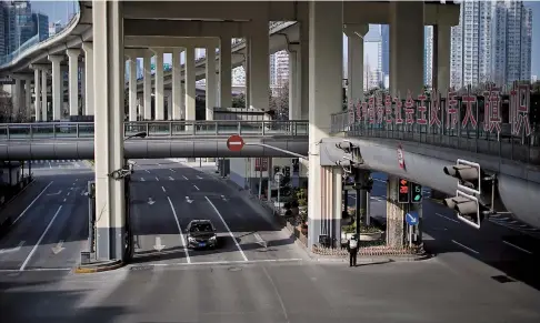  ??  ?? Main roads with only one vehicle are seen in Shanghai yesterday. — Reuters