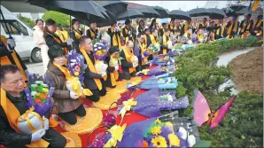  ?? LIU KEGENG / CHINA NEWS SERVICE ZHAO QIRUI / FOR CHINA DAILY ?? Top: A water burial service in the Minjiang River, Fujiang province. Above: People at a garden burial ceremony in Huai’an, Jiangsu province.