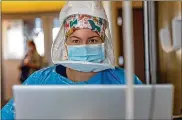  ?? PREMIER HEALTH PHOTO ?? Nurse Taylor Spicer wears full personal protective equipment while entering patient data in a COVID-19 unit at Miami Valley Hospital.