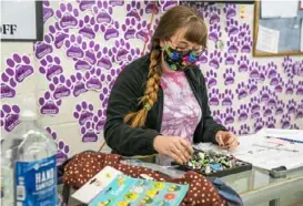  ?? Andrew Rush/Post-Gazette ?? Cailin Rankin, community engagement manager, helps a customer with merchandis­e Friday at the Beaver County Humane Society Thrift Store in Beaver Falls. Part of the store sustained damage from a broken pipe.