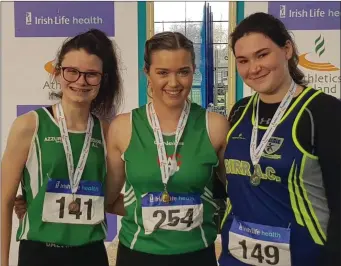  ??  ?? Zoe Mohan of Cushinstow­n AC (centre) is pictured after breaking the national indoor record for the Junior Women’s weight for distance with a throw of 5.92m at the recent National Indoor Junior and U-23 Championsh­ips in Athlone IT. Zoe’s clubmate Michael O’Sullivan came second in the U-23 shot put with a personal best throw of 11.21m.