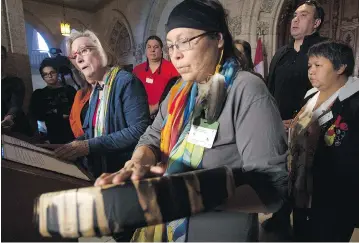  ?? ADRIAN WYLD / THE CANADIAN PRESS ?? Chief Marcia Brown Martel touches her drum as Crown-Indigenous Relations and Northern Affairs Minister Carolyn Bennett announced a compensati­on package for Indigenous victims of the ‘60s Scoop on Parliament Hill Friday.