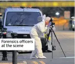  ??  ?? Forensics officers at the scene