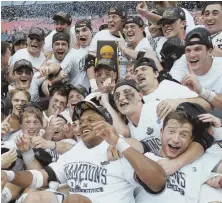  ?? AP PHOTO ?? ’DOGS HAVE THEIR DAY: Yale players celebrate with the trophy after winning the first men’s lacrosse national championsh­ip in program history yesterday in Foxboro.