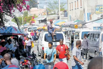  ?? AP ?? Pedestrian­s and commuters fill a street in Port-au-Prince, Haiti, on Tuesday.