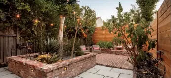  ??  ?? Top: A decadent master suite opens to a spa bathroom with a freestandi­ng soaking tub and rain shower. Above: The backyard features a brick planting bed and brick patio. Below: Custom intricate details are found throughout the home, like this guest bathroom door.