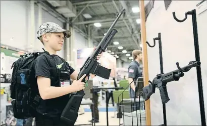  ?? LOREN ELLIOTT / AFP ?? Blaise Maliskey, de 11 años, prueba un arma en la feria de la convención anual de la NRA, en Dallas