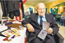  ?? U-T FILE ?? George Coburn holds his Purple Heart medal and others he finally received in 2019 that he earned for his military duty in World War II.