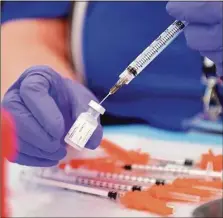  ?? File photo ?? Nurses prepare shots during a COVID-19 vaccinatio­n clinic last year.