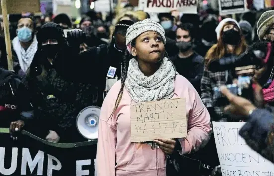  ?? CHENE         E  E ?? “Trayvon Martin també en tenia 17”, diu un cartell de protesta a Chicago: l’edat de Rittenhous­e i d’un noi negre víctima d’un altre justicier