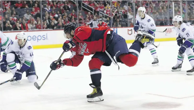  ?? — GETTY IMAGES ?? Alex Ovechkin of the Washington Capitals follows his shot on goal in the second period against the Vancouver Canucks at Verizon Center on Sunday in Washington. Ovechkin had a goal and an assist in the Capitals’ 3-0 shutout of the struggling Canucks.