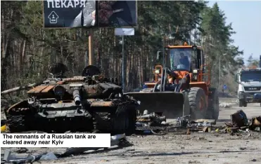  ?? ?? The remnants of a Russian tank are cleared away near Kyiv