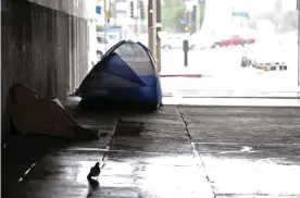  ??  ?? A homeless man huddles under a blanket in Los Angeles. Photograph: Luis Sinco/Los Angeles Times via Getty Images