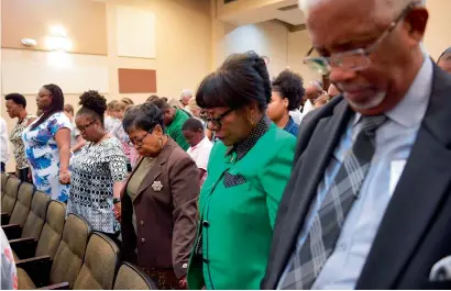  ?? AFP ?? Congregati­on members join hands as they pray during Sunday Service at the Fifth Ward Church of Christ in Houston. —