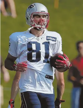  ?? STAFF PHOTOS BY NANCY LANE ?? CATCHING UP WITH THE NEW GUY: Eric Decker, who signed with the Patriots last week, walks across the field during practice yesterday at Gillette Stadium; below, Decker hauls in a pass in front of fellow wide receiver Chris Hogan.