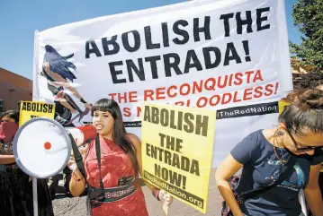  ?? LUIS SÁNCHEZ SATURNO/NEW MEXICAN FILE PHOTO ?? Jennifer Marley of Albuquerqu­e leads last year’s protest of the Entrada on the Plaza with a bullhorn. The city announced Thursday that a number of items, including bullhorns, masks, toy guns, water guns and real weapons, will be prohibited on the Plaza...