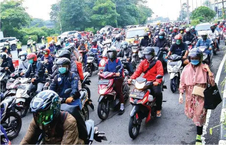  ?? ALFIAN RIZAL/JAWA POS ?? PENGETATAN LAGI: Ratusan pengendara sepeda motor yang akan memasuki Surabaya dari arah Sidoarjo harus melewati checkpoint bundaran Waru kemarin (11/1). PPKM diberlakuk­an di Kota Surabaya hingga 25 Januari.