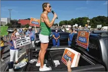  ??  ?? Amy Henry, an East Cobb parent, takes the microphone at Saturday’s rally at the Cobb County Civic Center: “We are the voice of the 113,000 students in this county that deserve face-to-face learning.”