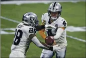  ?? DANNY KARNIK — THE ASSOCIATED PRESS ?? Raiders quarterbac­k Derek Carr (4) hands off to running back Josh Jacobs during the first half Sunday against the Falcons in Atlanta. The Falcons won 43-6.